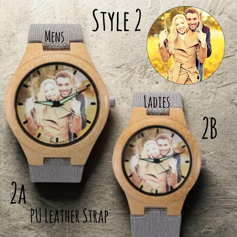 Puede incluir: Dos relojes de madera con una foto en la esfera y correas de cuero PU grises. Uno de los relojes est&aacute; etiquetado "MENS" y el otro "LADIES". Los relojes est&aacute;n etiquetados "2A" y "2B" y el estilo es "STYLE 2".