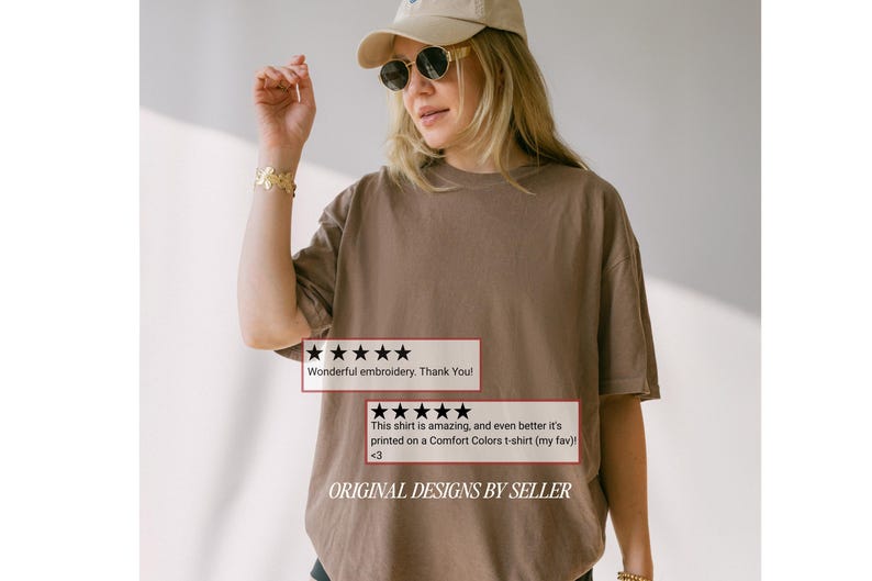 May include: A brown t-shirt with the text "ORIGINAL DESIGNS BY SELLER" and customer reviews. The shirt is worn by a person wearing sunglasses and a cap. The reviews say "Wonderful embroidery. Thank You!" and "This shirt is amazing, and even better it's printed on a Comfort Colors t-shirt (my fav) <3".