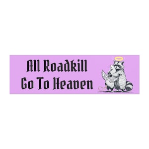Könnte beinhalten: Rechteckiger, lavendelfarbener Aufkleber mit dem Text "All Roadkill Go To Heaven" in schwarzer gotischer Schrift. Ein Cartoon-Waschbär mit Heiligenschein umarmt eine Maus mit Engelsflügeln.