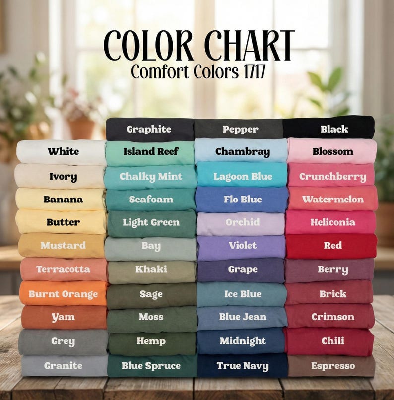 May include: A colour chart for Comfort Colors 1717 t-shirts, displaying a stacked grid of folded fabric swatches in various shades. Each swatch is labelled with its corresponding colour name, including White, Ivory, Banana, Butter, Mustard, Terracotta, Burnt Orange, Yam, Grey, Granite, Graphite, Island Reef, Chalky Mint, Seafoam, Light Green, Bay, Khaki, Sage, Moss, Hemp, Blue Spruce, Pepper, Chambray, Lagoon Blue, Flo Blue, Orchid, Violet, Grape, Ice Blue, Blue Jean, Midnight, True Navy, Black, Blossom, Crunchberry, Watermelon, Heliconia, Red, Berry, Brick, Crimson, Chili, and Espresso.