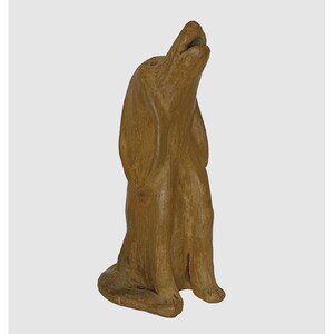 May include: A brown ceramic dog figurine standing on its hind legs with its head tilted back and mouth open. The figurine is made of a rough, textured clay.