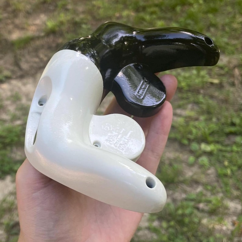 May include: A handheld metal pipe cutter tool featuring a glossy white finish on the main body and a contrasting glossy black finish on the adjustable cutting wheel assembly, with visible screw holes and a metallic adjustment knob.