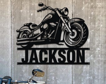 Pode incluir: Silhueta de motocicleta preta de metal com o nome "JACKSON" abaixo. A motocicleta está virada para a direita e tem um design detalhado.