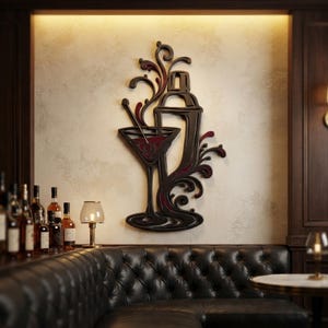 May include: A dark-toned wall art piece featuring a stylized cocktail shaker and a martini glass with swirling, decorative flourishes. The design incorporates deep red accents within the glass and the liquid splashes, creating a layered, dimensional appearance.