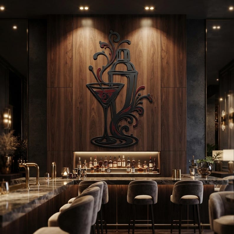 May include: A black wall art piece featuring a stylized cocktail shaker and a martini glass with swirling decorative accents and red details, mounted on a vertical wood panel above a bar counter with various liquor bottles and bar stools.