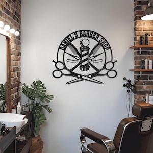 Pode incluir: Placa de metal preto com um poste de barbeiro, tesouras e navalhas. A placa diz "Daniel's Barber Shop".