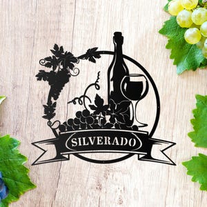 May include: Black metal wine bottle and glass with grapes and vines, with a banner that reads "SILVERADO".