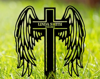 May include: Black metal cross with angel wings, personalised with the name "Linda Smith" and the dates "1945-2022".