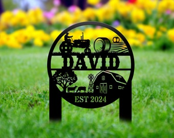 May include: Black metal yard sign with a farmhouse theme. The sign features a tractor, hay bale, barn, windmill, and trees. The name "DAVID" is displayed in a banner across the top, and the text "EST 2024" is at the bottom.