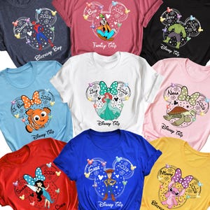 May include: A collection of colorful t-shirts featuring Disney-themed designs. Each shirt displays a Mickey Mouse head with a character graphic, name, and the year 2026. The shirts come in various colors, including blue, red, pink, and yellow.