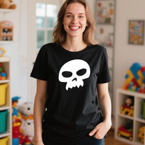 Peut inclure: T-shirt noir avec un motif de cr&acirc;ne blanc. Le cr&acirc;ne a de grandes orbites et une m&acirc;choire dentel&eacute;e. Le t-shirt est de style col rond classique.
