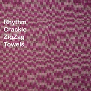 May include: A close-up of a pink and white patterned fabric with the words "Rhythm Crackle ZigZag Towels" printed on it.