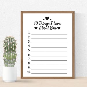 May include: A framed print with the text "10 Things I Love About You" above numbered lines. The frame is brown, and the print is on a white background. A cactus in a white pot is to the left of the frame.