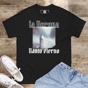 Peut inclure: T-shirt noir avec un imprimé graphique blanc d'une femme en robe blanche avec le texte "la llorona llanto eterno".