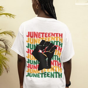 May include: White t-shirt with a black raised fist graphic and the word "Juneteenth" repeated in red, yellow, and green.