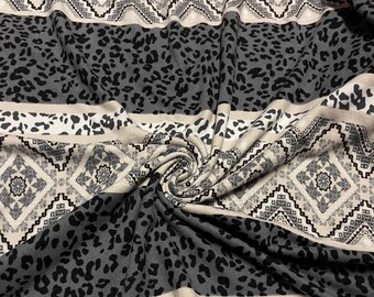 May include: A close-up of a fabric with a repeating pattern. The design features alternating bands of gray leopard print, geometric diamond shapes, and neutral beige stripes. The fabric is soft and appears to be knit.