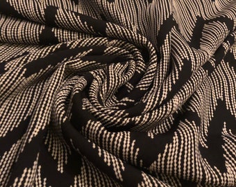 May include: Black and white fabric with a repeating chevron pattern. The design features rows of white dots forming zigzag lines against a black background. The fabric is draped and folded, creating a textured appearance.