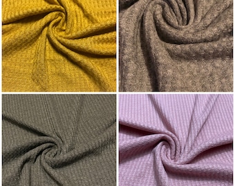 May include: Four fabric swatches in different colors: mustard yellow, brown, dark gray, and light pink. The fabric has a waffle texture.