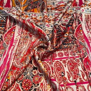 May include: A vibrant textile with a paisley pattern in shades of red, white, orange, and black. The fabric features intricate floral and geometric designs, with vertical stripes of bright pink.