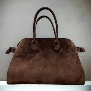 Fashionable suede tote handbag with a soft suede top handle, perfect for women seeking a stylish and versatile accessory