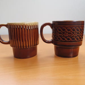 Zestaw dwóch ceramicznych kubków w paski i kwiaty z lat 70., szkliwionych, składanych, z możliwością układania w stosy