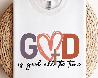 May include: White t-shirt with a purple "G", a red heart with a brown cross inside, and an orange "D". The text "is good all the time" is written below the letters.