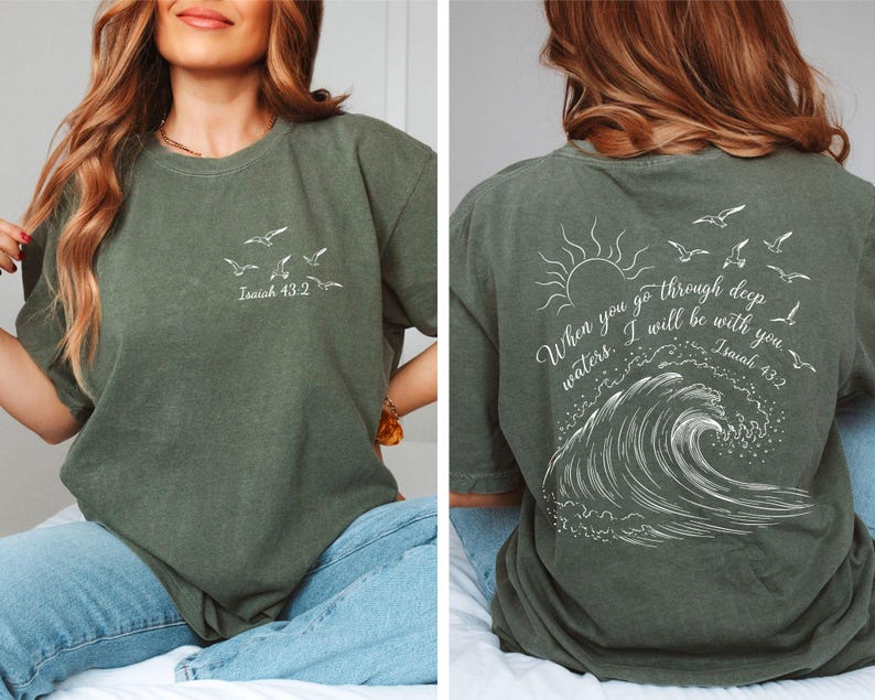 May include: Olive green t-shirt with white graphic of birds and text "Isaiah 43:2" on the front. The back features a sun, birds, wave design, and the text "When you go through deep waters, I will be with you. Isaiah 43:2."