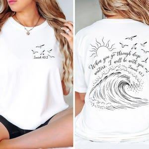 May include: White t-shirt with a small flock of birds and the text "Isaiah 43:2" printed on the front. The back features a wave design, sun, more birds, and the quote "When you go through deep waters. I will be with you. Isaiah 43:2."