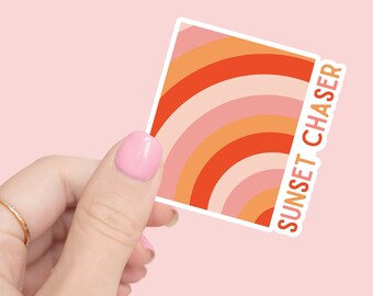 May include: A sticker with a colorful abstract design of orange, pink, and red curved lines. The sticker has the text "SUNSET CHASER" on the right side.