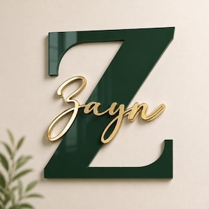 Könnte beinhalten: Ein großer, dunkelwaldgrüner Buchstabe Z mit glänzender Oberfläche. Überlagert in der Mitte des Buchstabens befindet sich der Name Zayn in einer metallisch goldenen Schreibschrift. Das Design hat eine geschichtete, dreidimensionale Optik.