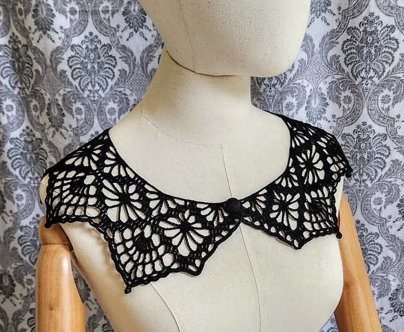 May include: A black crocheted collar with a decorative button in the center.