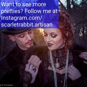 May include: A couple in a forest setting, the woman is wearing a black lace top with a pearl necklace and a cameo pendant, the man is wearing a black suit with a fur collar. The text in the image reads "Want to see more pretties? Follow me at Instagram.com/scarletrabbit.artisan"