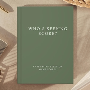 Könnte beinhalten: Ein salbeigrünes Hardcover-Buch mit weißem Text, der WHO'S KEEPING SCORE? und CARLY & IAN PETERSON GAME SCORES lautet. Das Buch hat einen sauberen, einfarbigen Vorderdeckel mit zentrierter Typografie und einem professionellen, matten Finish.