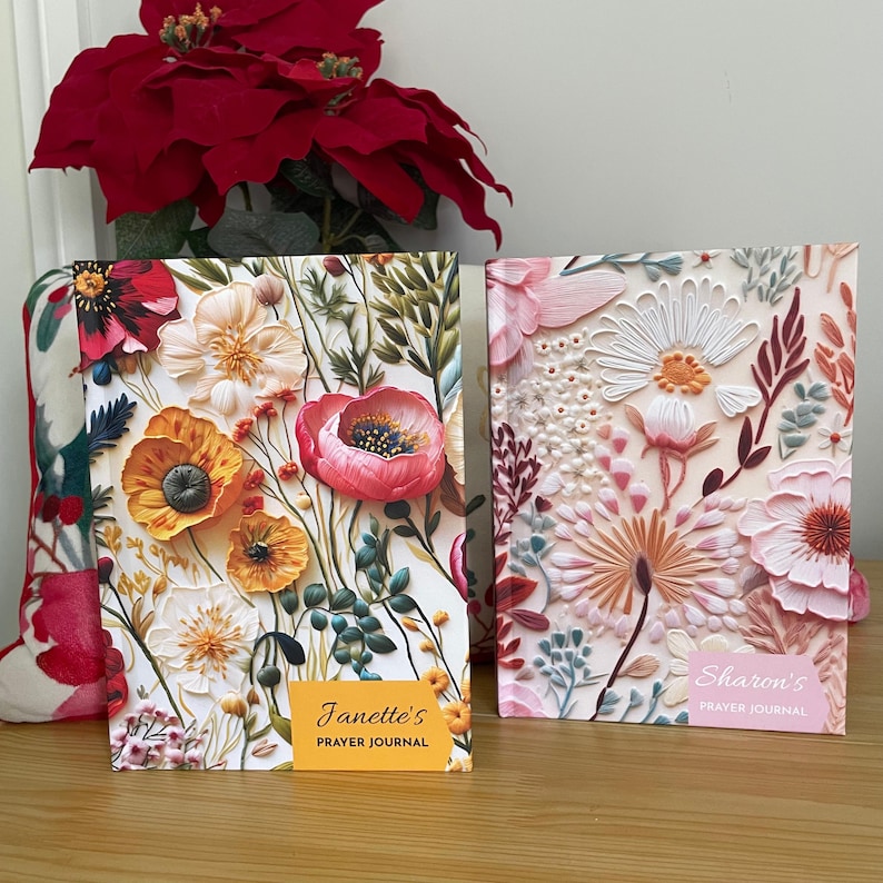 K&ouml;nnte beinhalten: Zwei gebundene Notizb&uuml;cher mit floralen Mustern und den Titeln "Janette's Prayer Journal" und "Sharon's Prayer Journal".