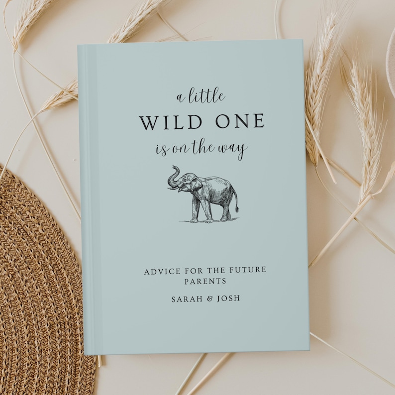 May include: A light blue book with the text "a little WILD ONE is on the way" and a black and white illustration of an elephant. The text "ADVICE FOR THE FUTURE PARENTS SARAH & JOSH" is printed below the illustration.