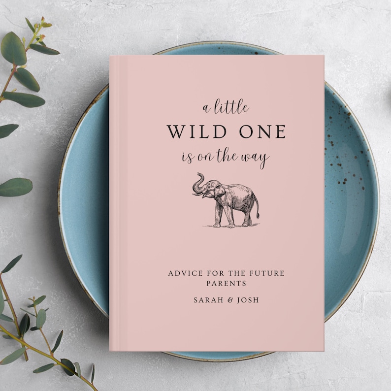 May include: A pink book with the text "a little WILD ONE is on the way" and a black and white illustration of an elephant. The text "ADVICE FOR THE FUTURE PARENTS SARAH & JOSH" is printed below the illustration.