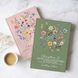 May include: Two hardcover journals, one in dusty pink and one in sage green, each featuring a watercolor wildflower bouquet. The green journal displays the text: Chapter 25, Your story is one of courage and kindness, let this new chapter be filled with big dreams and happy adventures, you are the author of a beautiful story, Sally Elke.