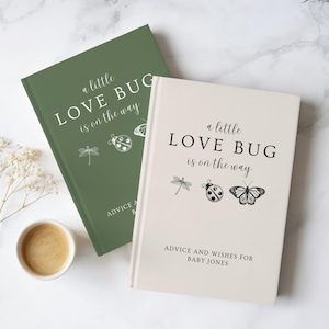 Op de afbeelding: Twee baby-adviesboeken. Eén is saliegroen, de andere crème. Beide boeken hebben de tekst "a little LOVE BUG is on the way" met illustraties van libellen, lieveheersbeestjes en vlinders. Het crème boek heeft de tekst "ADVICE AND WISHES FOR BABY JONES".