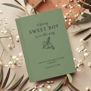 K&ouml;nnte beinhalten: Ein salbeigr&uuml;nes Buch mit dem Text "a berry SWEET BOY is on the way" und einer Illustration von Blaubeeren. Das Buch enth&auml;lt auch den Text "ADVICE FOR THE FUTURE PARENTS SARAH & JOSH".