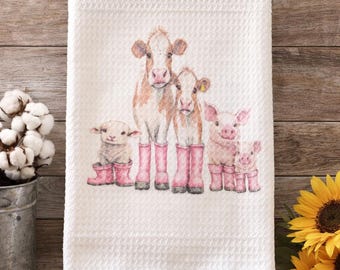 May include: White waffle dish towel, 16" x 24", featuring a watercolor illustration of farm animals wearing pink boots. The towel has the words "Farmhouse" and "Waffle Dish Towel" printed on it.