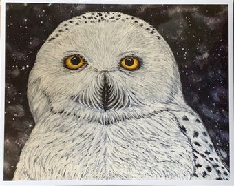 May include: A close-up of a snowy owl with bright yellow eyes. The owl is facing the camera with its feathers fluffed up. The background is a dark blue with white speckles.