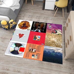 May include: A colorful rug featuring album covers from the rapper Kanye West's album "The Life of Pablo". The rug is made up of nine squares, each featuring a different album cover. The album covers are in a variety of colors, including red, blue, green, and yellow. The rug is a great way to show your love for Kanye West and his music.