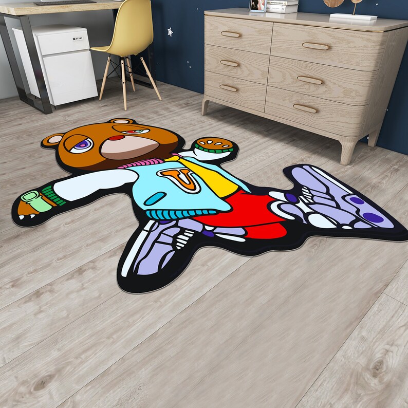 May include: A brown bear wearing a blue and yellow jacket with red pants and purple and white sneakers. The bear is laying on its back with its arms and legs outstretched. The bear is on a wooden floor.