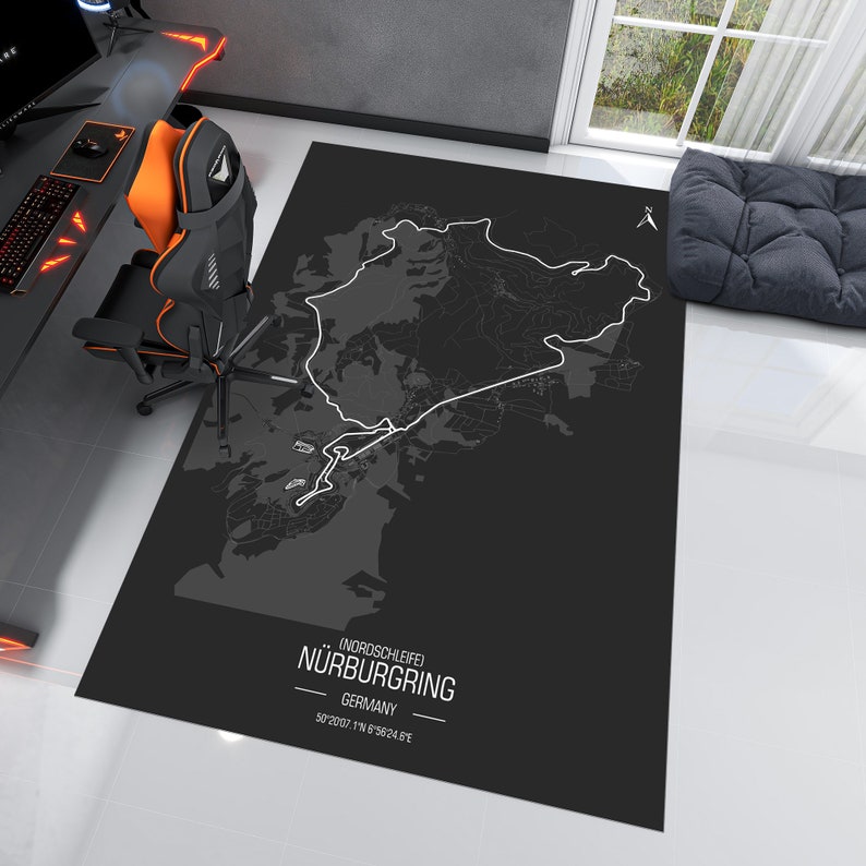 May include: A black and white map of the Nordschleife Nurburgring race track in Germany. The map is printed on a black rug with the text "Nordschleife Nurburgring, Germany, 50.2007&deg; N 6.9824&deg; E".