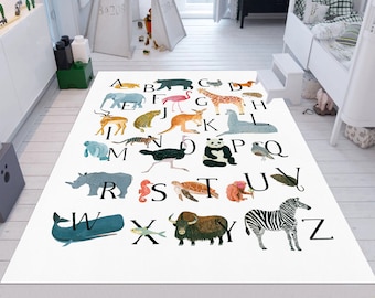 May include: A white alphabet rug with colourful animal illustrations for each letter. The rug features a rhino, whale, zebra, panda, flamingo, giraffe, and other animals.