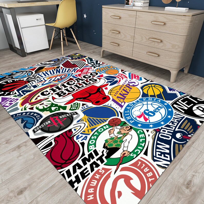 May include: A white area rug with a colorful collage of NBA team logos, including the Chicago Bulls, Los Angeles Lakers, Boston Celtics, Miami Heat, and New Orleans Pelicans.