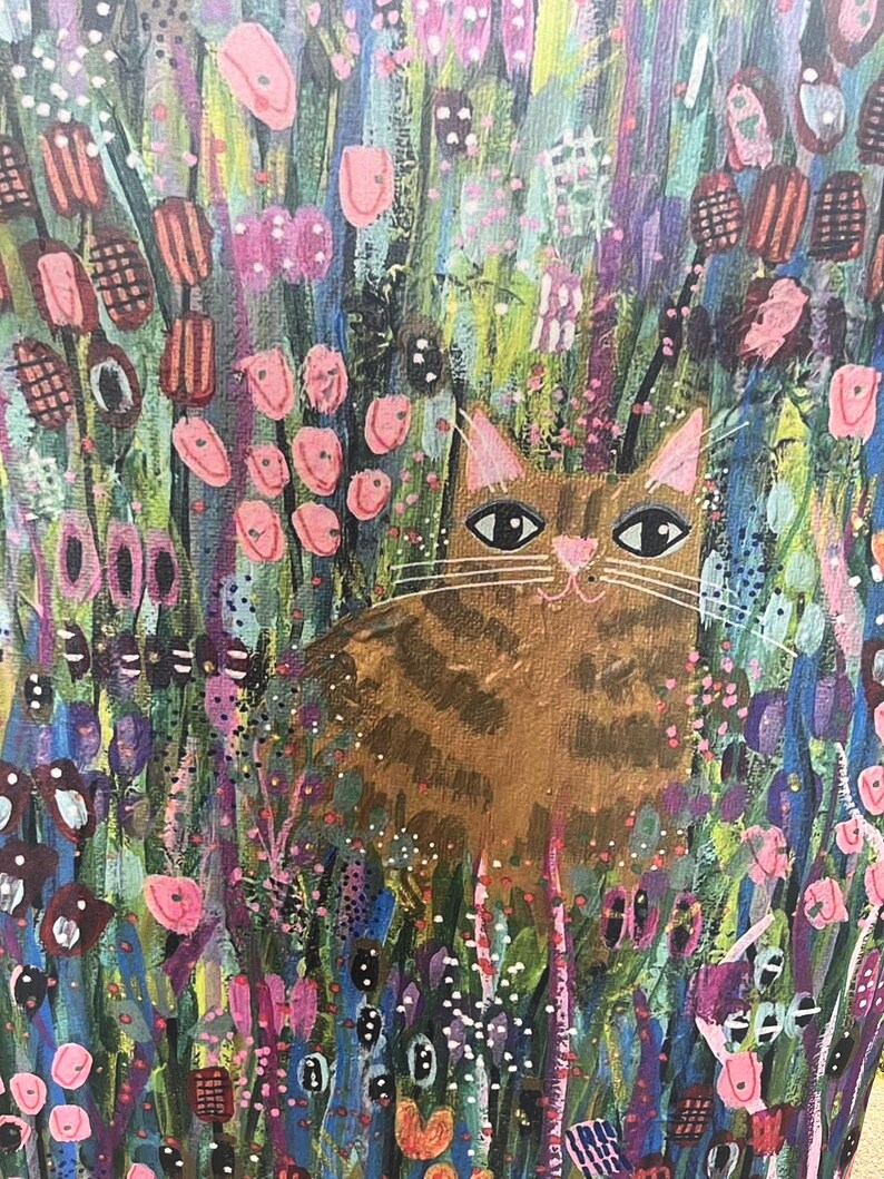 May include: A painting of a brown tabby cat sitting in a field of colorful flowers. The cat has green eyes and a pink nose. The flowers are pink, purple, and blue.