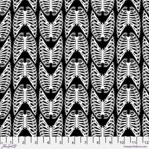 May include: Black fabric with a repeating pattern of white rib cages. The design includes various orientations of the rib cage, creating a visually dynamic and anatomical theme. The fabric has a ruler along the bottom edge.