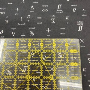 May include: A clear plastic ruler with yellow markings. The ruler is divided into inches and fractions of an inch. The ruler is on a black surface with white text.