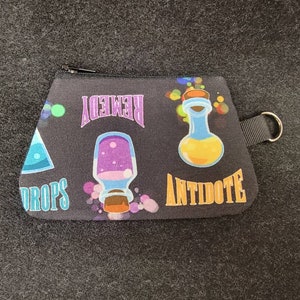 May include: Black zippered pouch with a colorful print of potion bottles and the words "Remedy", "Drops", and "Antidote".